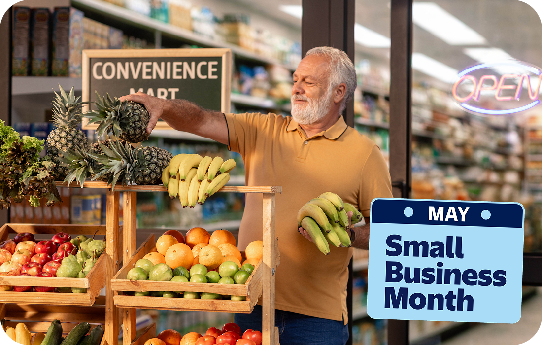 A man stocks fresh fruit outside a convenience mart. Text reads, May, Small Business Month.