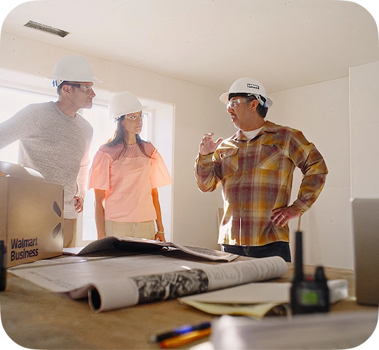 Battres Construction owner Izzy consults with clients in a house under construction.